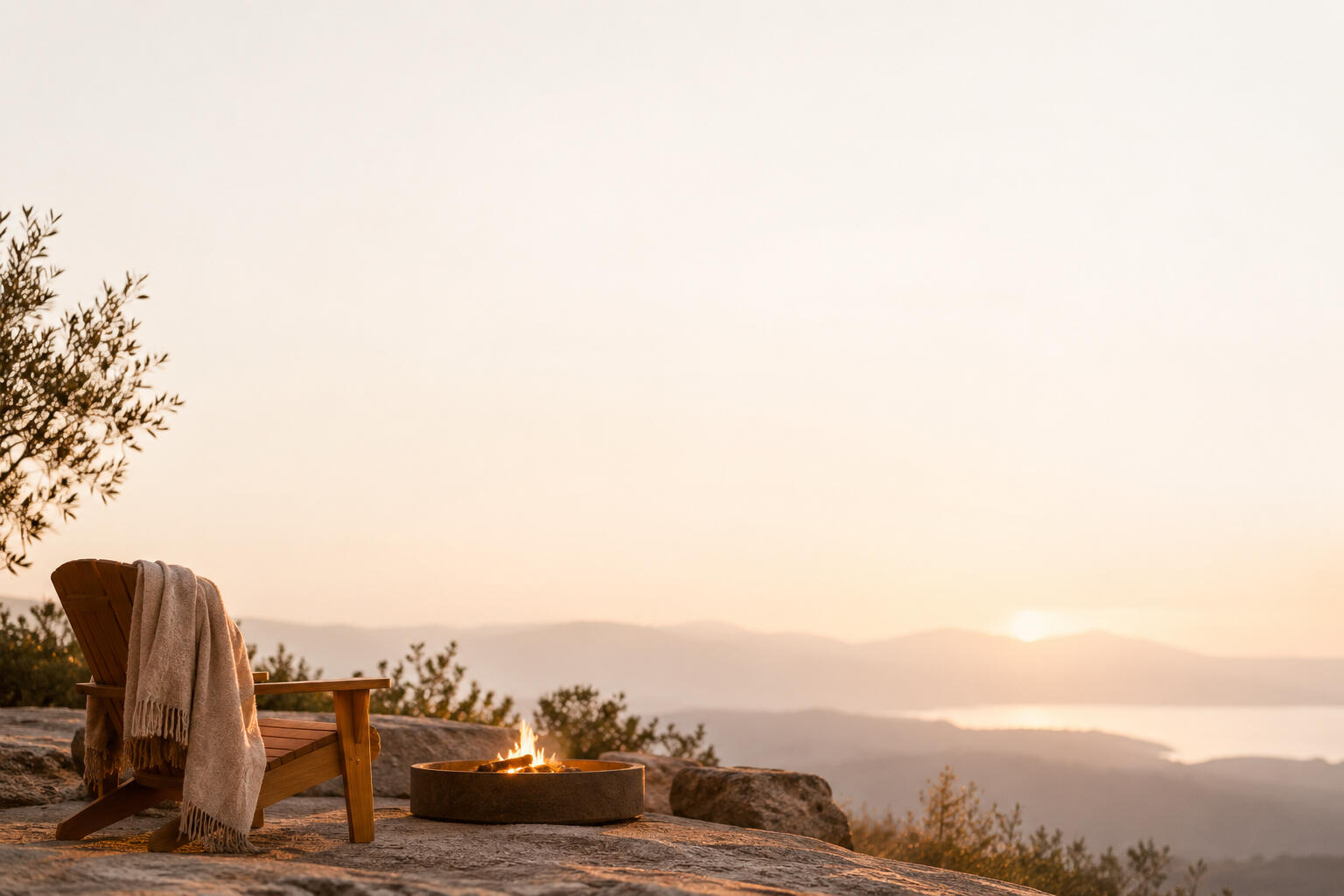 A quiet resting place beside a small campfire, overlooking distant mountains at sunset.